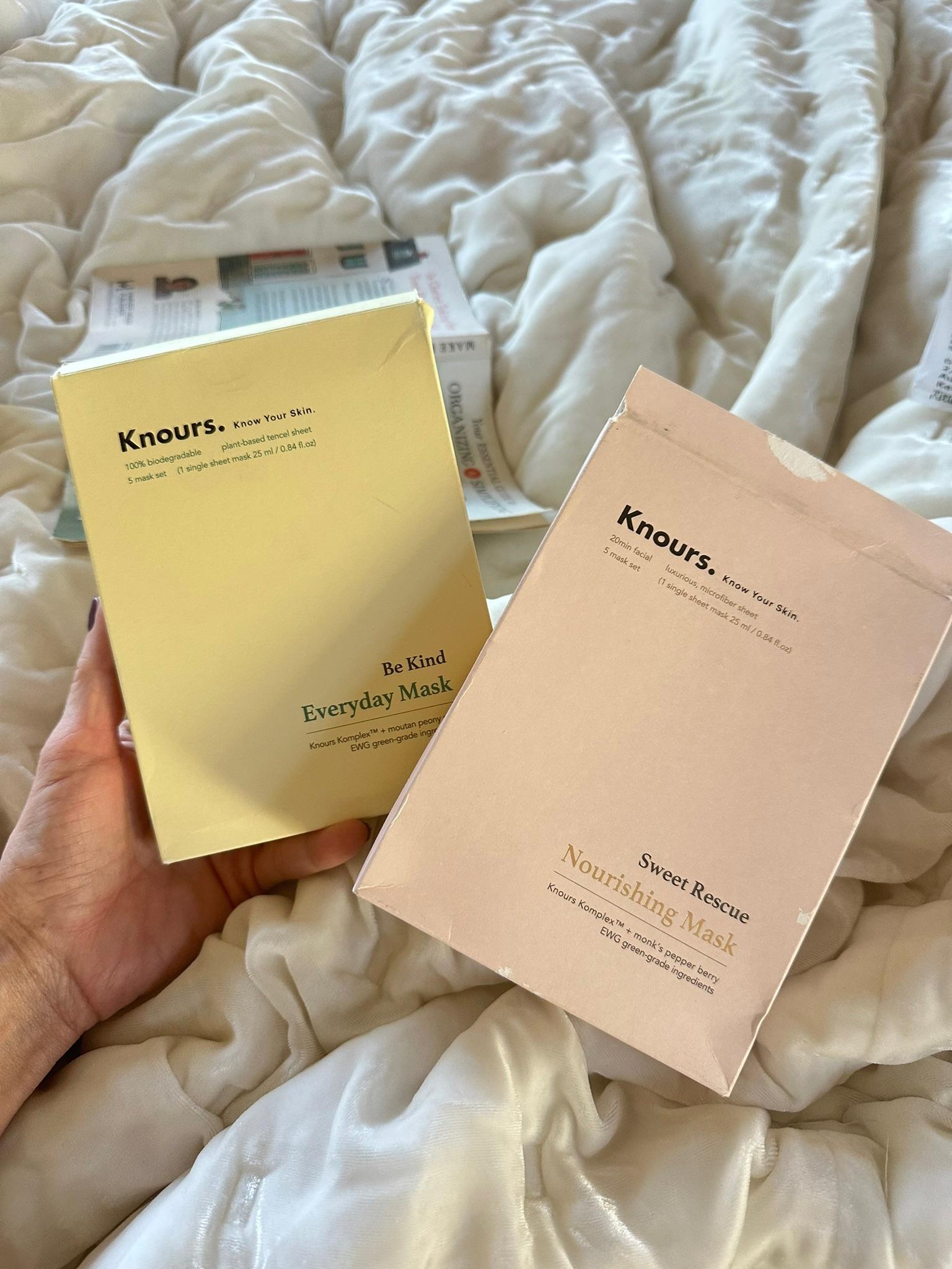 Two boxes of Knours face masks held over a bed